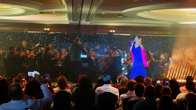 Rosy Arango acompañada por la Orquesta Filarmónica de Acapulco, interpretando canciones de Juan Gabriel en el Salón Ocean del hotel Princess Mundo Imperial, durante la inauguración de la temporada de verano