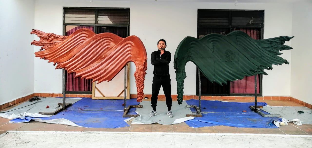 Un ala representa la Bandera de las Tres Garantías y otra la actual bandera de México