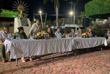 El escritor Luis Marín Sánchez sentado en la mesa de honor junto a autoridades y participantes del evento cultural, durante la presentación de su libro Noches serenas con sabor a mar en San Nicolás, Coyuca de Benítez.