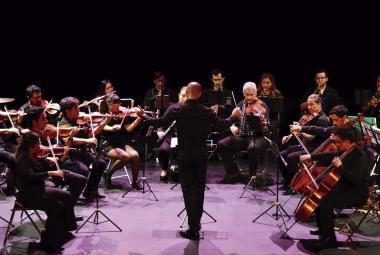 Concierto de la Orquesta Típica de Jalisco en el Teatro Alarife Martín Casillas, mostrando a los músicos en acción durante una presentación en vivo